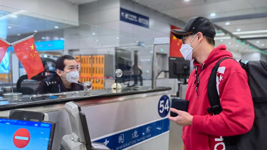 上海机场移民管理警察正查验出入境旅客.孙潇镥摄