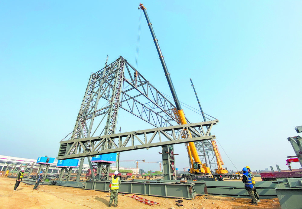 空客项目施工现场,工程设备正在吊装飞机库钢结构部件