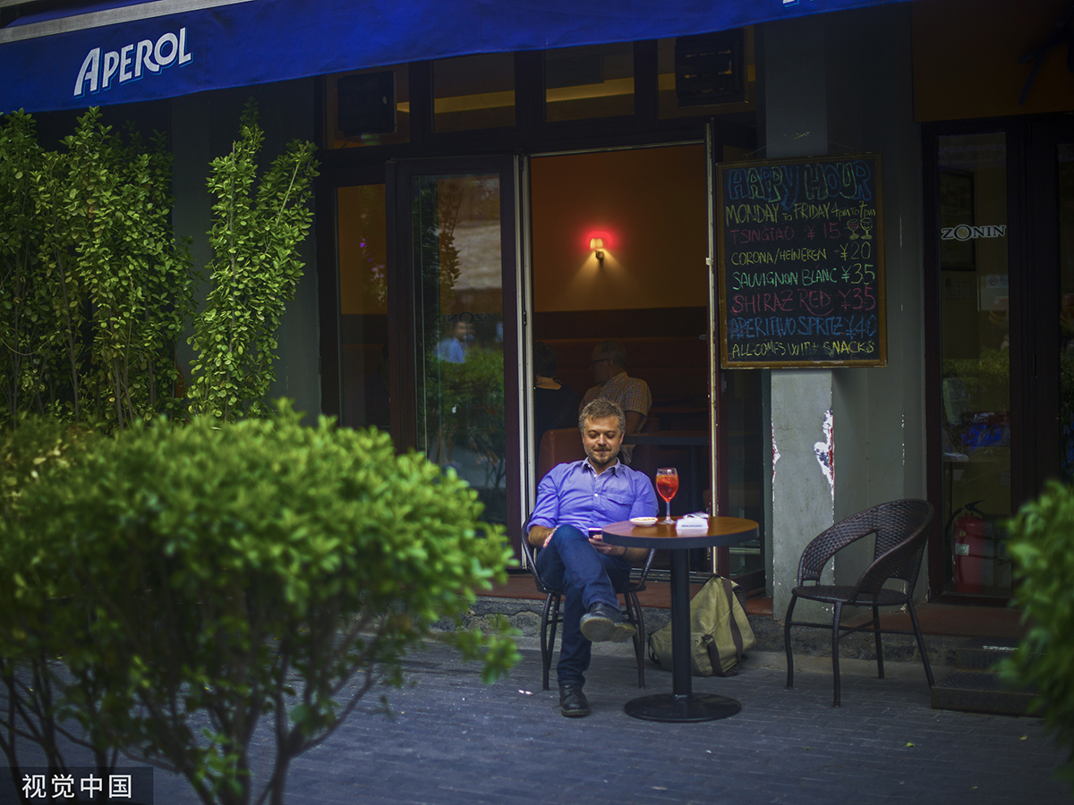 2015年6月25日,三里屯,一位老外在酒吧享受午后的阳光.