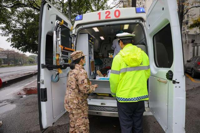 武警官兵和交警人员一起把受伤人员送上救护车.侯旭达/摄