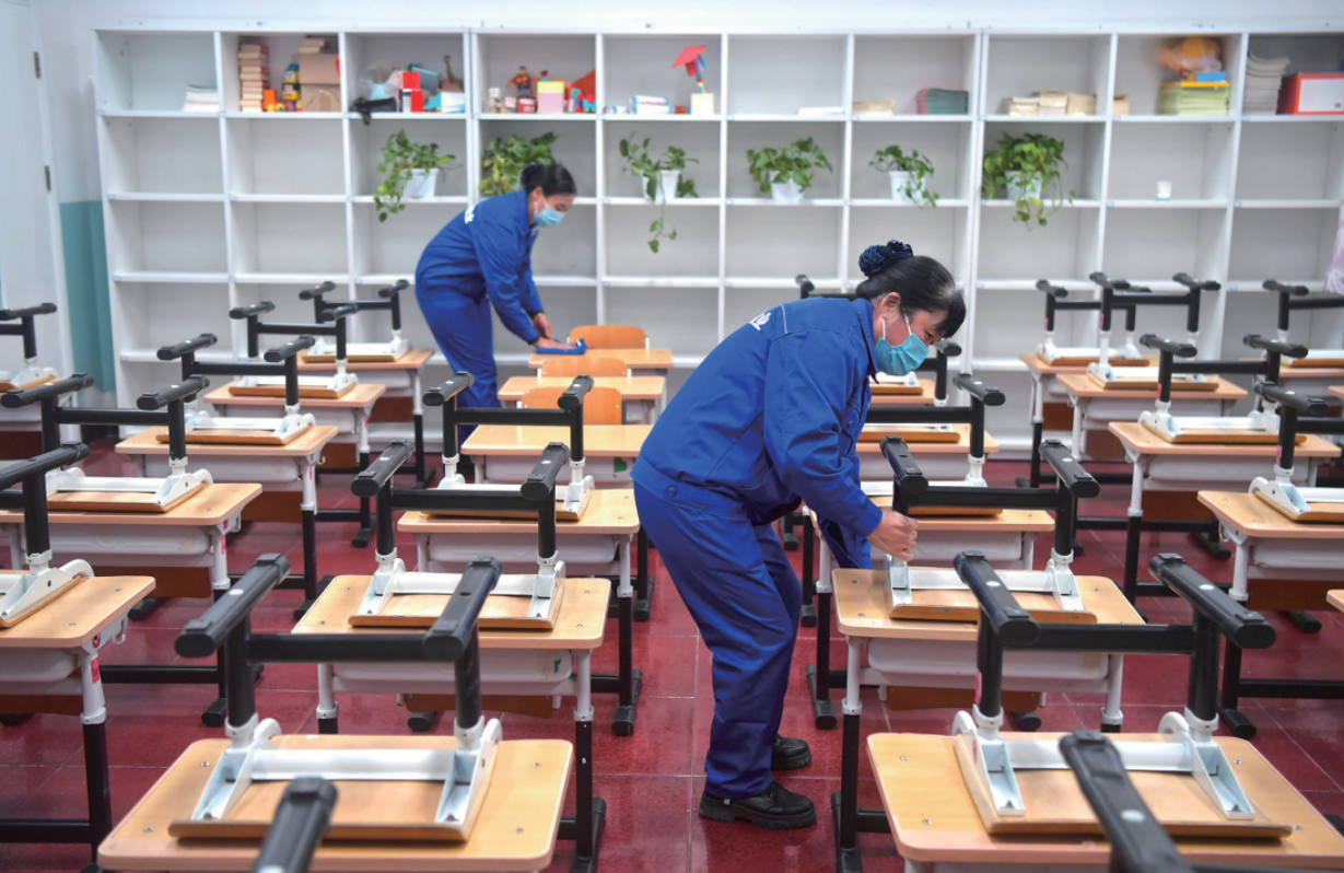 2月9日,东四九条小学,工作人员在整理教室桌椅. 李木易 摄