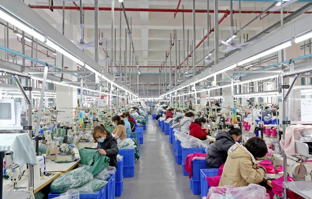 毕节市晶煌制衣有限公司生产车间内工人在忙于生产.