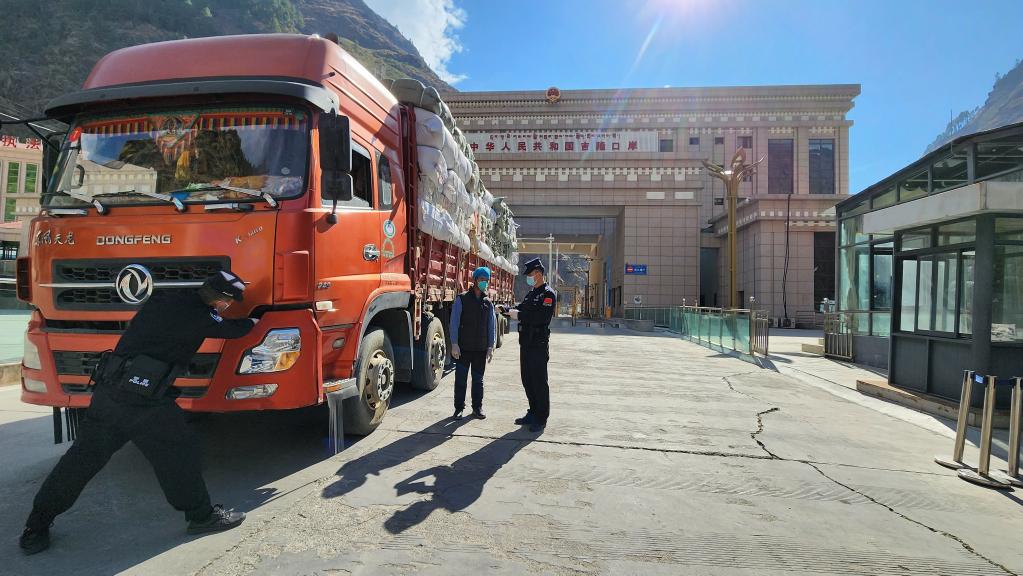 吉隆出入境边防检查站口岸执勤队民警检查出境货车和司乘人员.