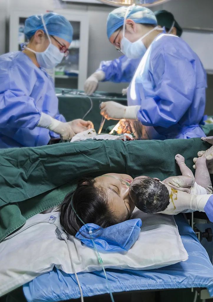 安徽宣城一名产妇在亲吻新生儿.视觉中国供图.