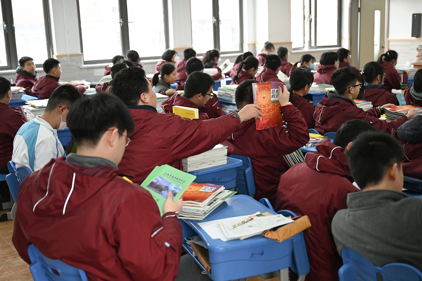 2023年2月14日,南洋模范中学.传递新学期课本的学生.