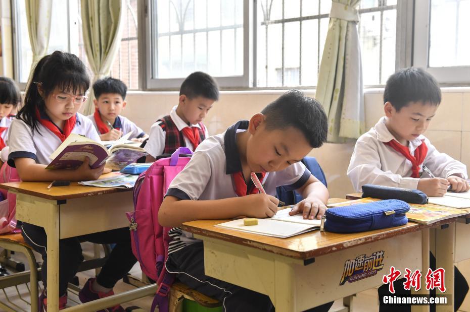 资料图：广州市朝天小学部分低年级学生放学后在特定的托管教室内做作业。中新社记者 陈骥旻 摄