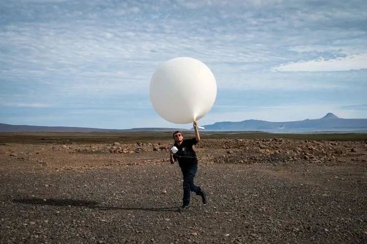 资料图片：2022年12月25日，一个气象气球正准备在法国凯尔盖朗岛释放。（法新社）