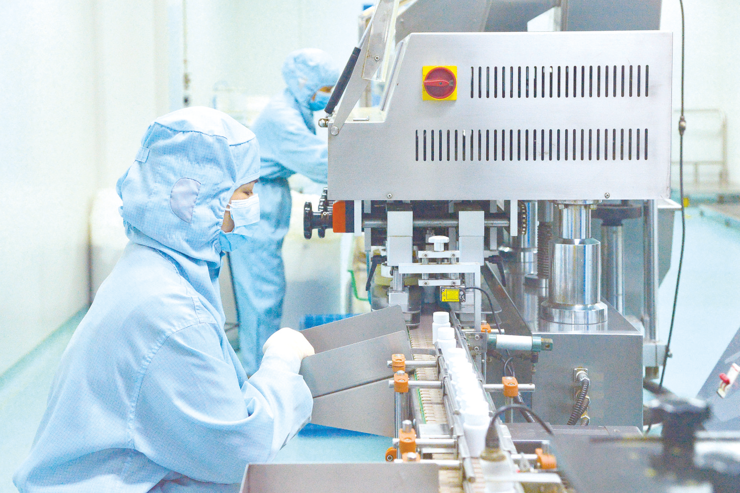 在南宁百会药业的固体制剂车间,工人在生产线上进行瓶分装产品生产