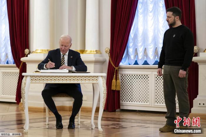 当地时间2023年2月20日，乌克兰总统泽连斯基看着美国总统拜登在马林斯基宫签署留言簿。