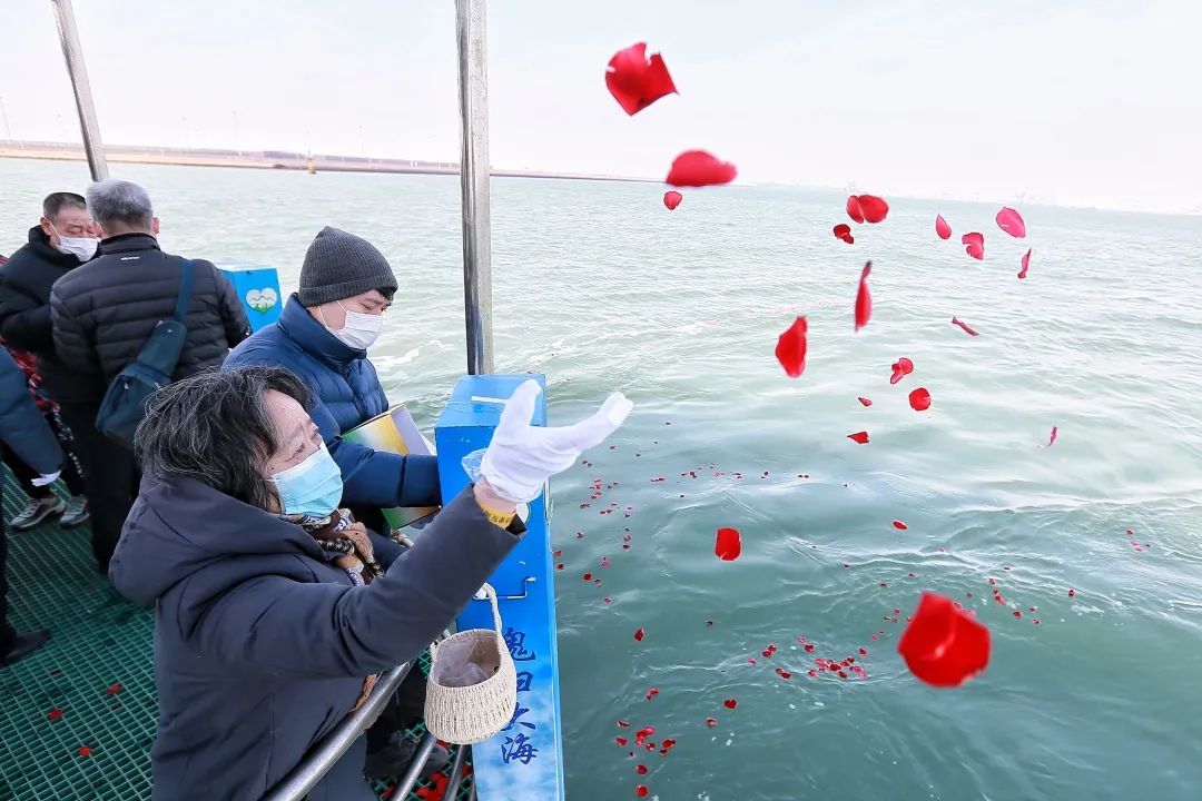 海葬仪式现场,工作人员为逝者敬献花篮.