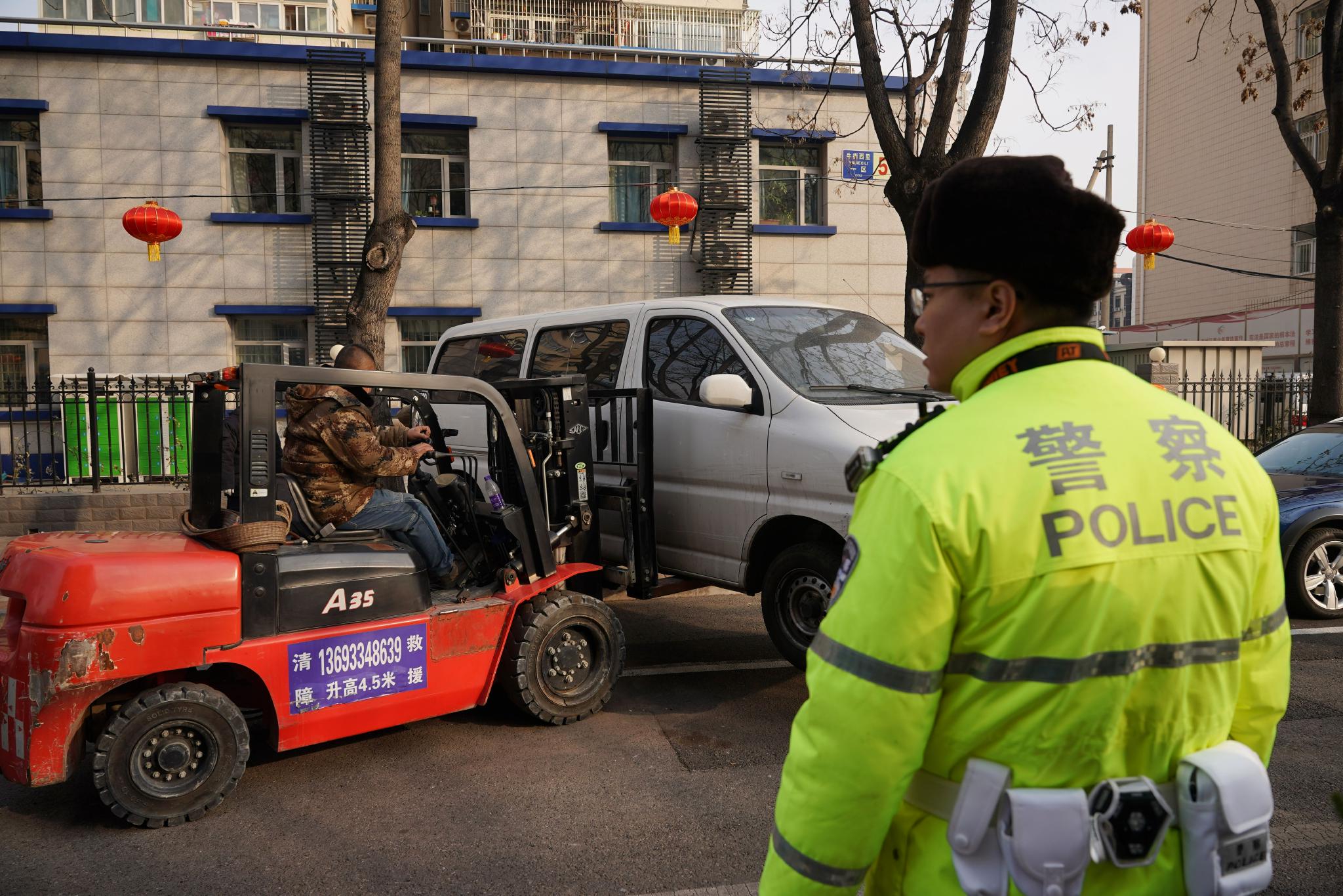在交警的指挥下，叉车对联系不上车主的违停车辆进行挪移。新京报记者 王贵彬 摄