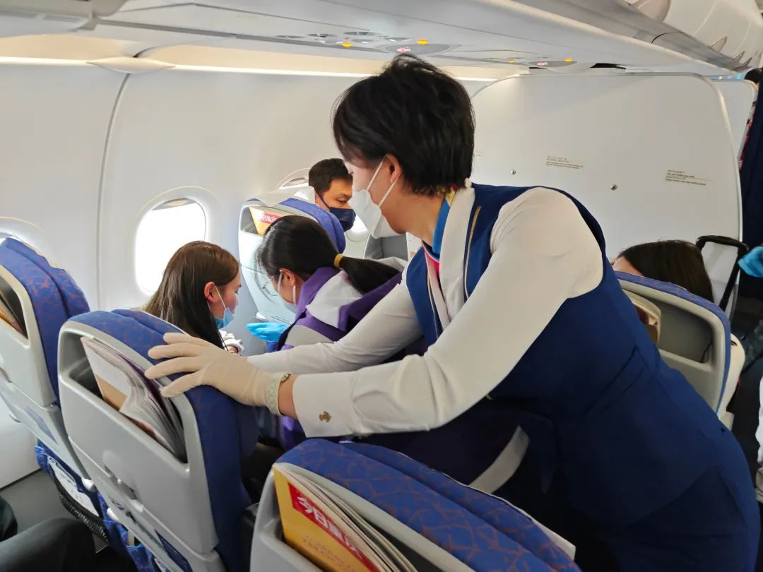 空乘人员对患病女童进行救护.&nbsp; 重庆航空供图