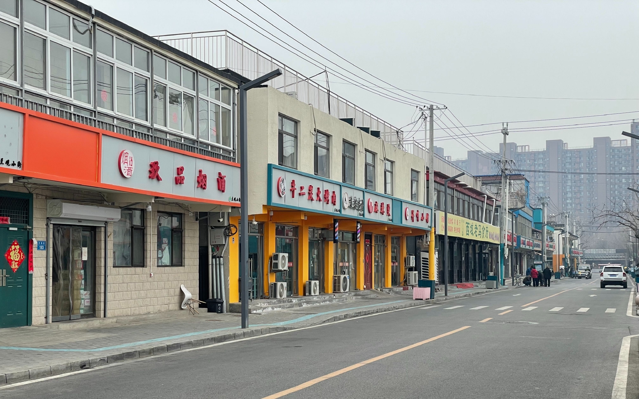 眼下的兰各庄村，商业街道路两侧的建筑错落，颜色上则呈现着统一的色调。新京报记者 田杰雄 摄