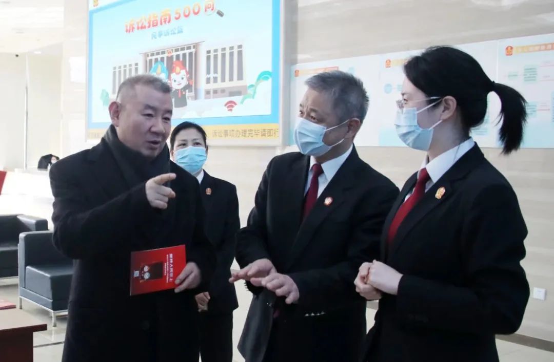 图为马一德（左一）在北京二中院调研。