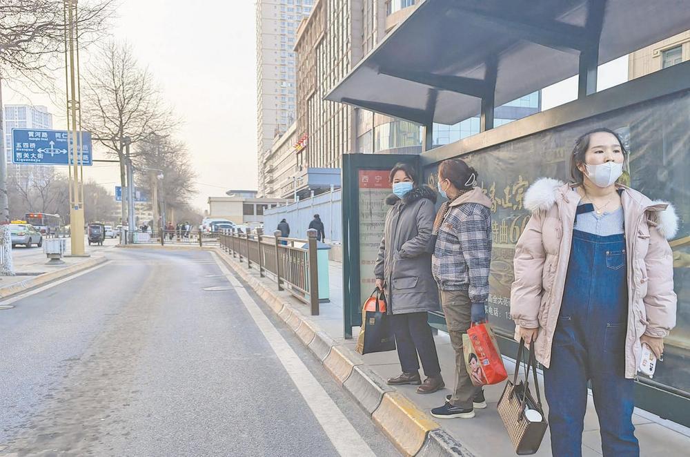 公交站台等候乘车的市民.季蓉/摄