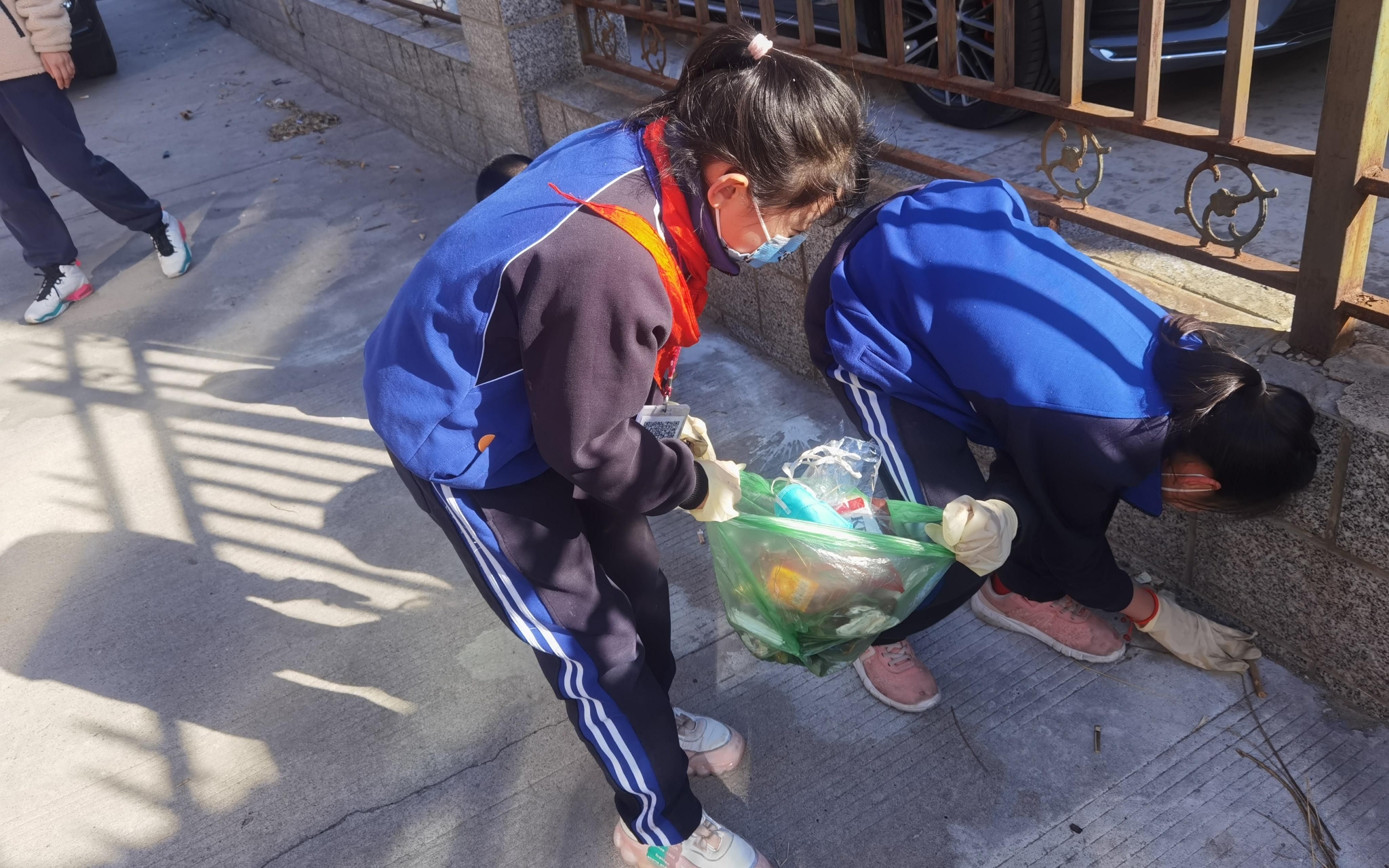 学生们两人一组捡拾垃圾.学校供图