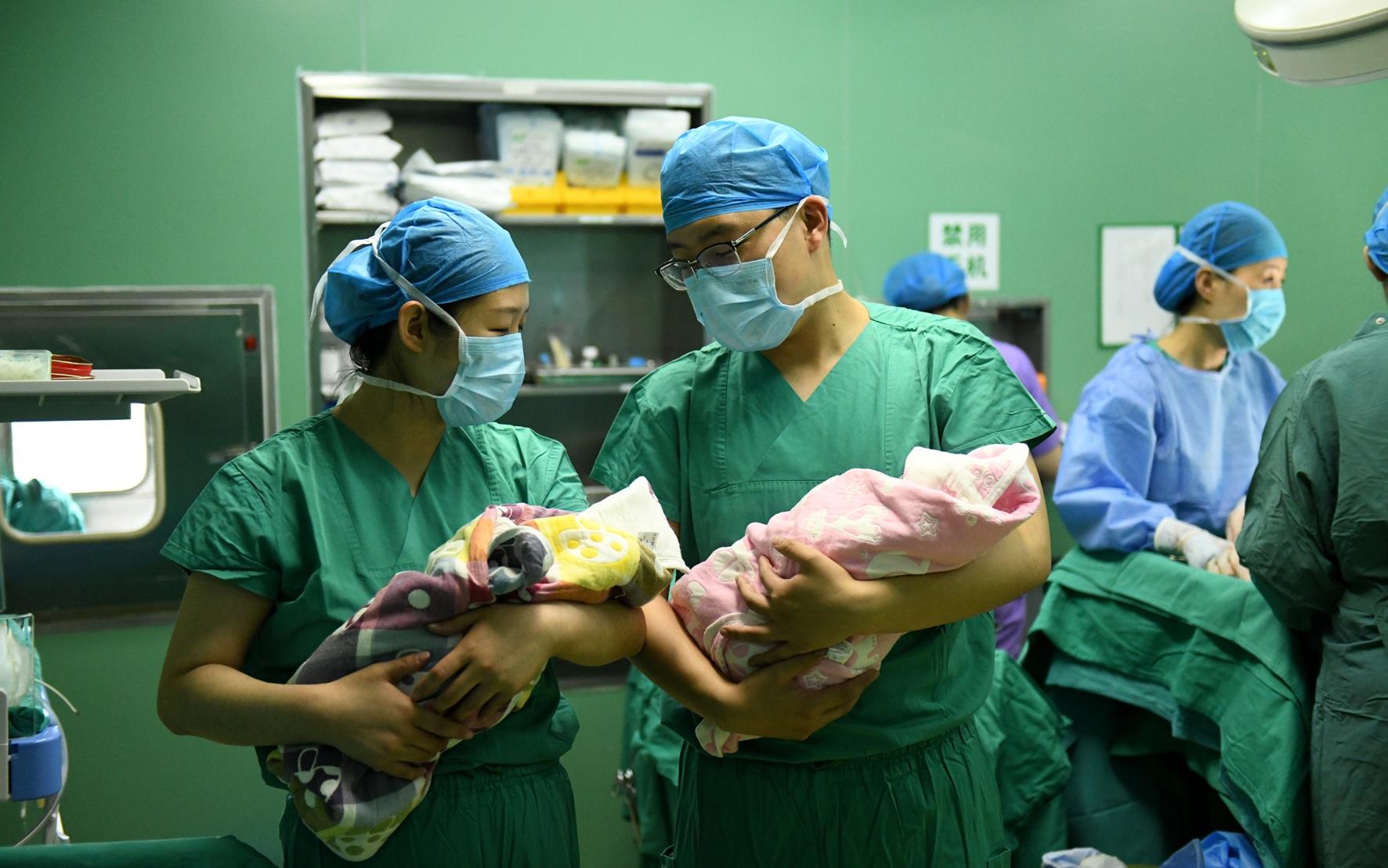 ▲资料图。河北省石家庄市妇产医院，护士抱着刚出生的双胞胎婴儿。图/新华社
