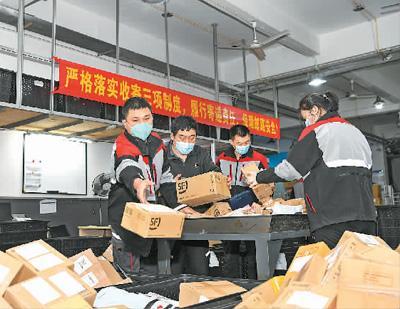 顺丰深圳南山科技园站点快递小哥杨磊（左一）和同事们忙着分拣快递。新华社记者 梁 旭摄
