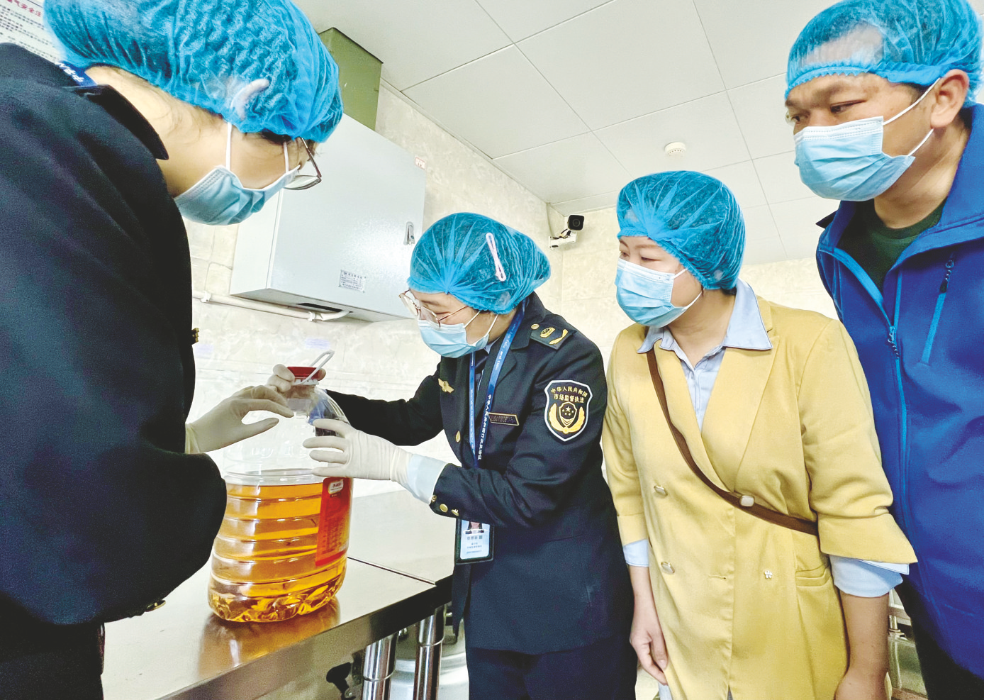 &nbsp;市场监管部门工作人员与家长代表共同检查学校食堂使用的食用油