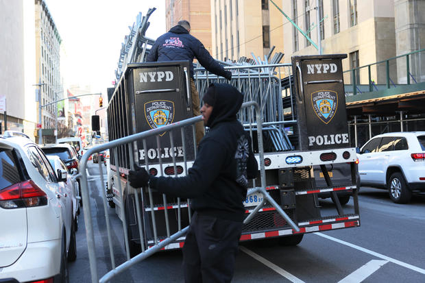 纽约警方工作人员于 当地时间3月20日在曼哈顿刑事法院前卸下路障。图自CBS