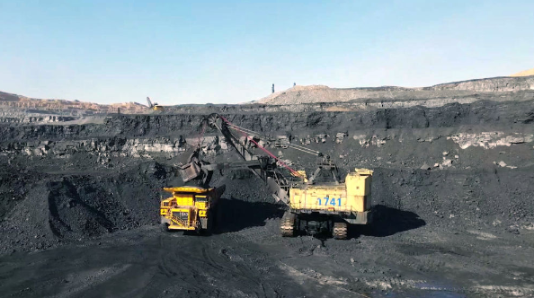 在山西一处露天煤矿,工作人员正在操作工程车辆装运煤炭