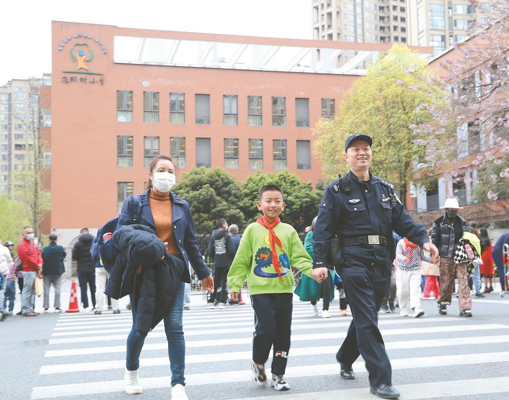 "护学岗"民警正在护送小朋友过马路