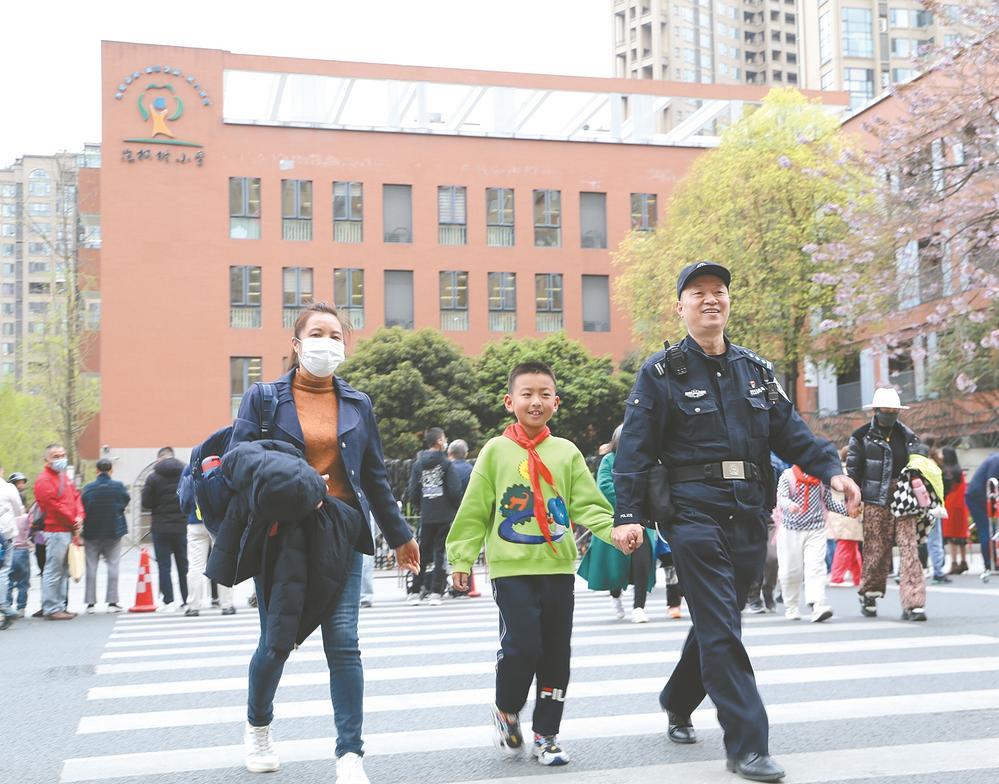 “护学岗”民警正在护送小朋友过马路