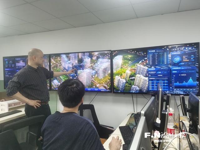 郑崇勇(左)介绍厦门电子城数字孪生园区情况.记者 朱榕 摄
