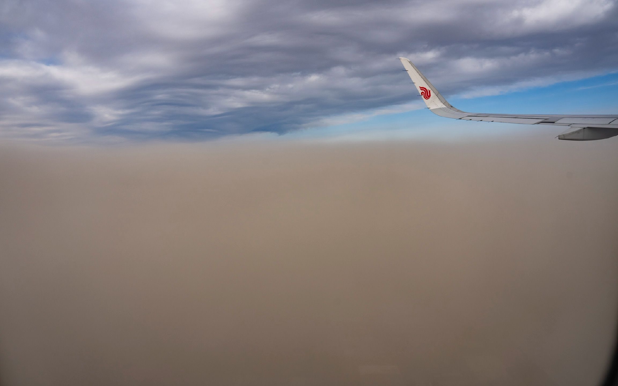 2023年3月22日，北京首都国际机场飞机起飞两分钟后穿过沙尘。新京报记者 陶冉 摄