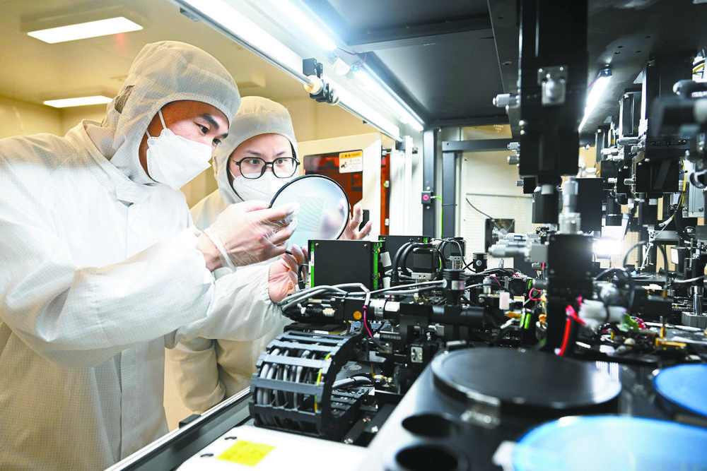 昊光电科技有限公司的技术人员在芯片测试机生产车间查看设备运行状态