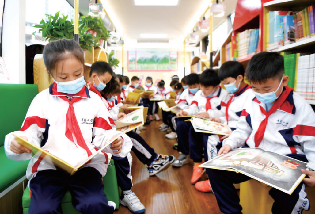 学生在湖南长沙市青园友谊小学巴士图书馆内上绘本阅读课.