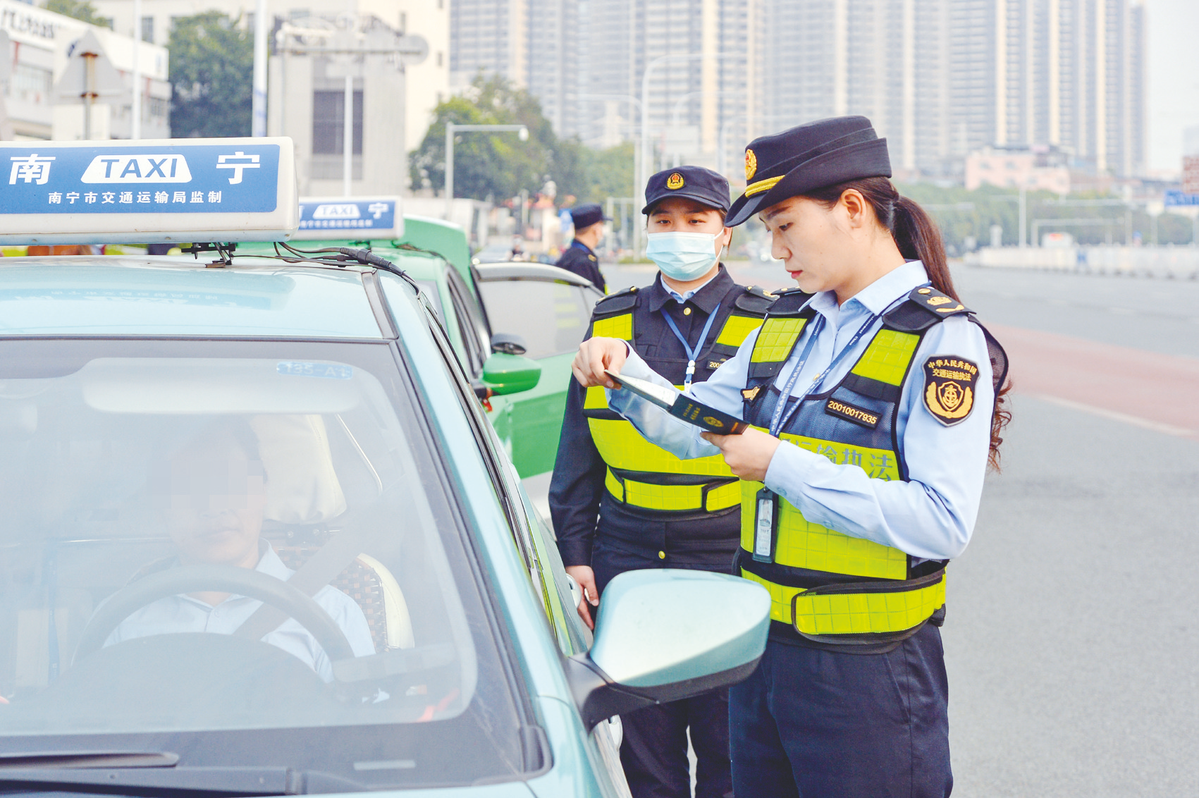     南宁市交通执法支队队员在江南客运站核验出租车相关证件。 （黄维业 摄）