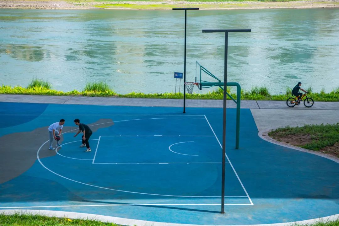 重庆市渝中区黄沙溪高架桥下,市民在长江边的篮球场打球.邹乐 摄