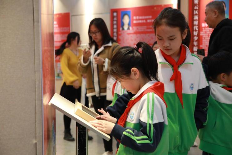 学生在北京市密云区博物馆阅读“新时代好少年”的典型事迹（北京市密云区供图）