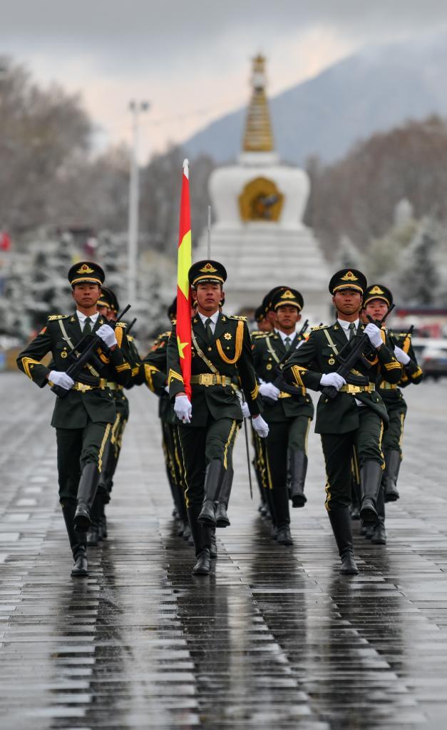 国旗护卫队迈着整齐划一的步伐，把五星红旗送到广场升旗处（3月28日摄）。新华社记者晋美多吉 摄