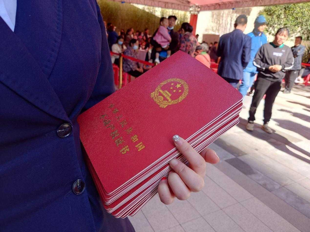 在阳光的照耀下,红色的房产证显得格外耀眼