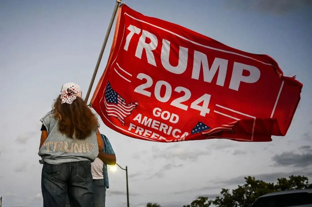▲當地時間2023年3月30日，美國佛羅里達州，美國前總統特朗普的支持者在佛羅里達州棕櫚灘的海湖莊園附近舉行集會，舉著“特朗普2024”的旗幟。圖/視覺中國