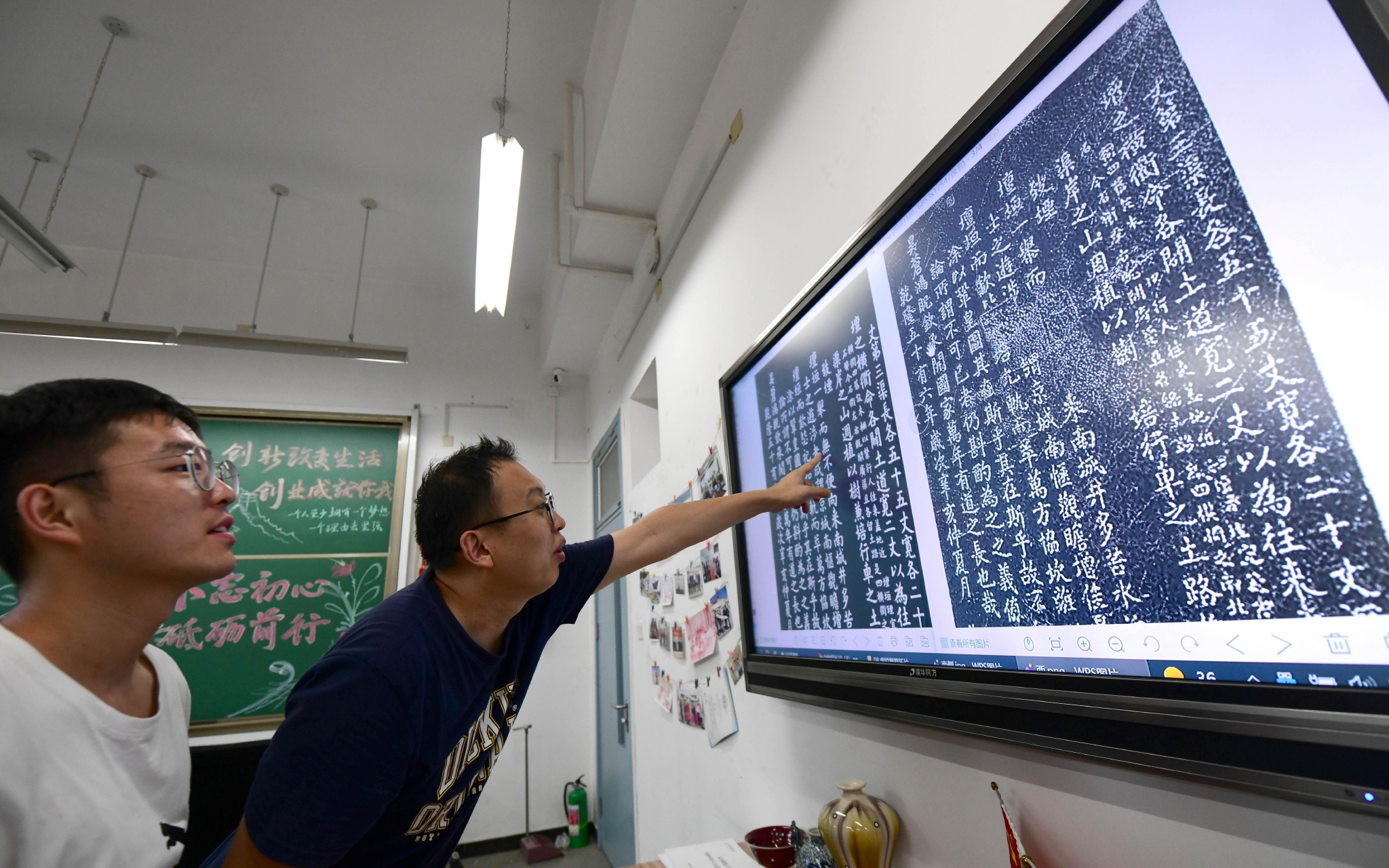 北京建筑大学教师董友强（左二）和学生一起观察石碑的数字拓片。新京报记者 李木易 摄