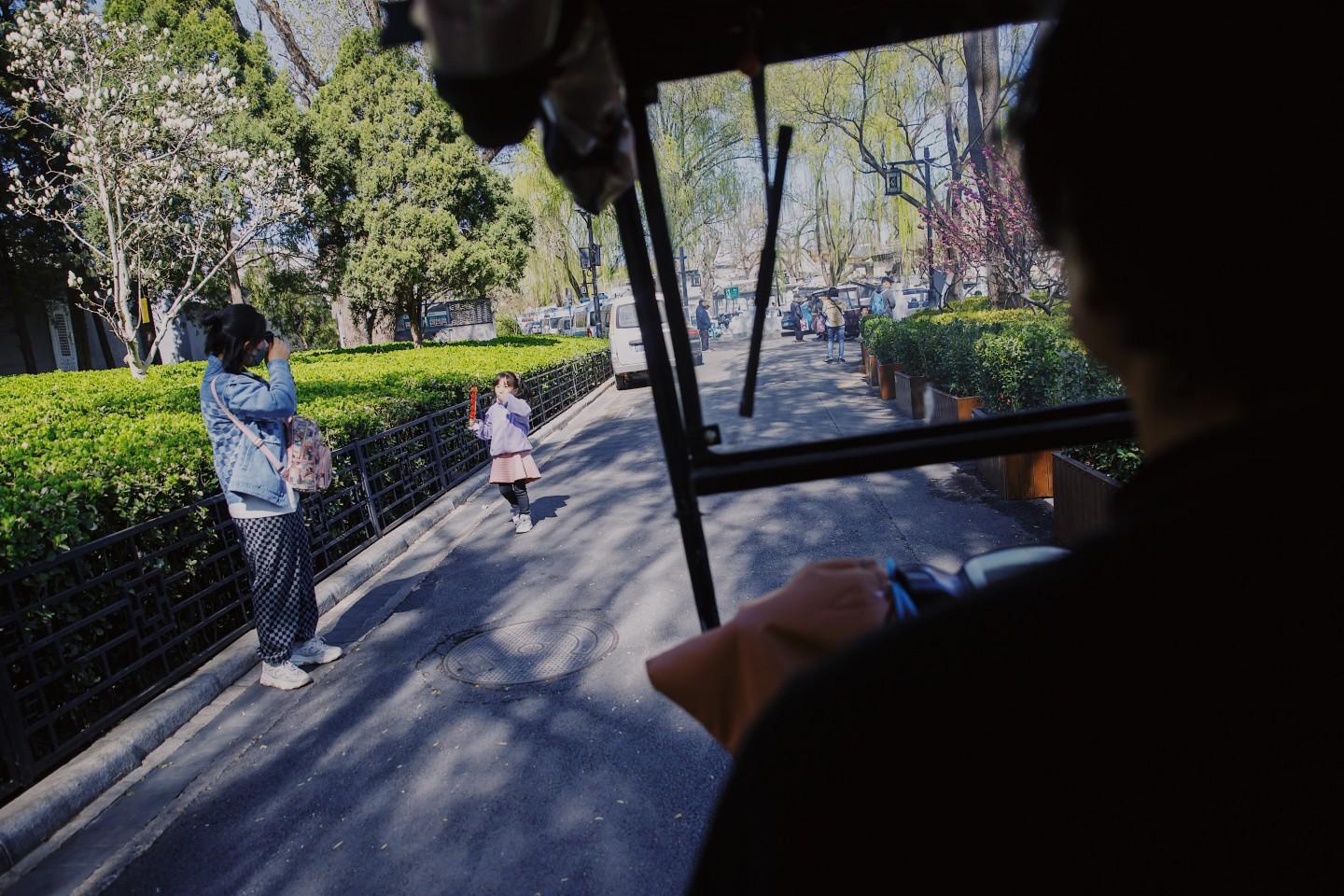 3月27日，后海，刘春宏开着电动三轮车穿行在春色之中。新京报记者 郑新洽摄