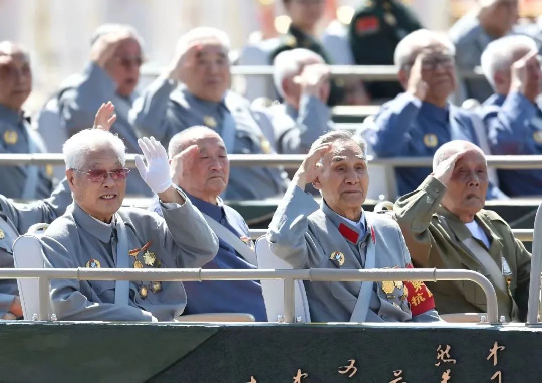 康明才(左一)在阅兵时举起左手