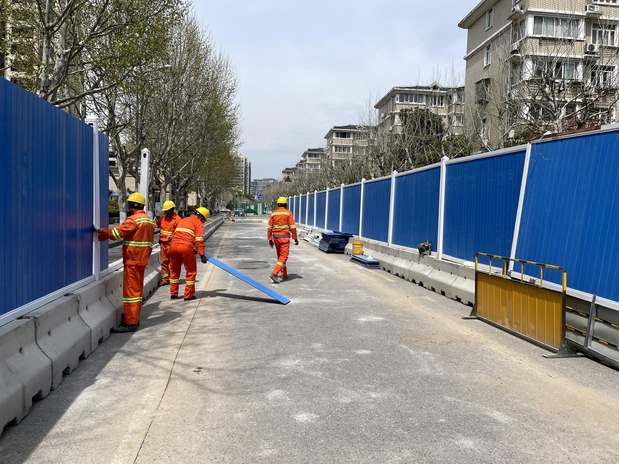 4月3日,姚虹路吴中路路口的施工现场,有工人在道路中间安装围挡.