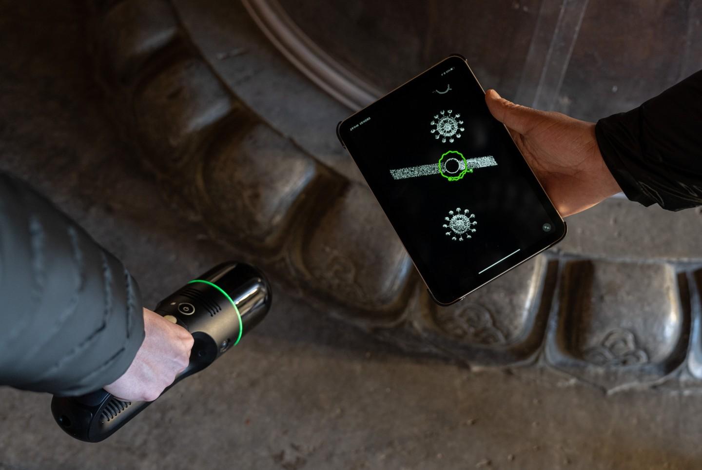 2月19日，太庙享殿，北京市测绘设计研究院测绘人员使用手持式三维激光扫描仪，采集金丝楠木柱子的莲花柱础激光点云。