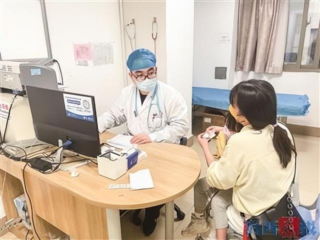 近期,市儿童医院门急诊接诊的流感患儿增多.图为医生在给患儿看诊.