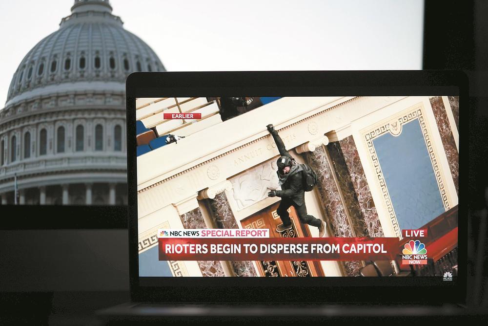 2021年1月6日拍摄的电视画面显示，一名抗议者闯入美国国会大厦