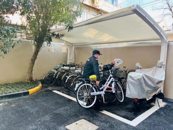 图说:物业人员正在老旧小区管理自行车