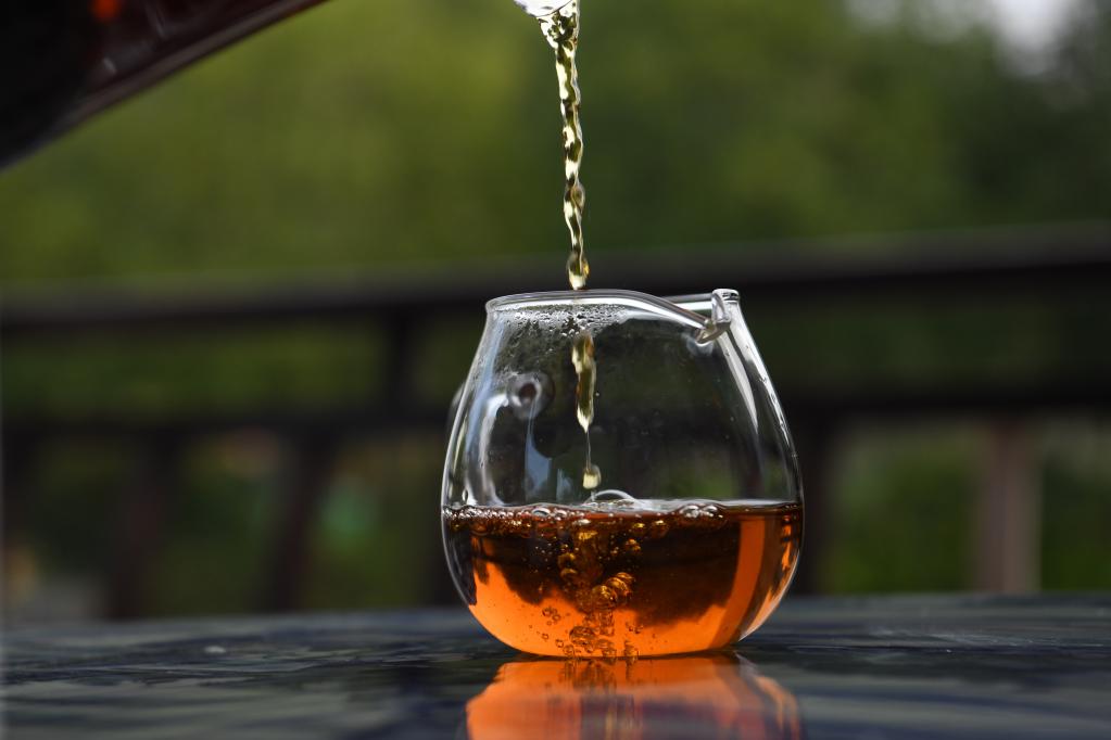 茶艺师在祁门县一处茶园倒茶.新华社记者 张端 摄