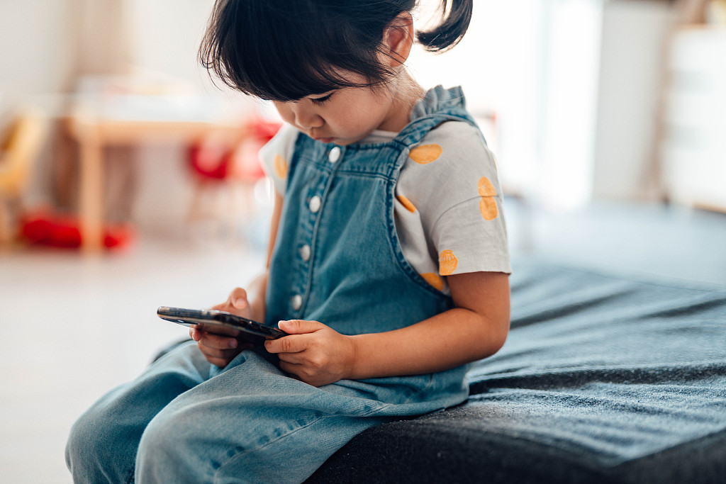 儿童在玩手机.视觉中国