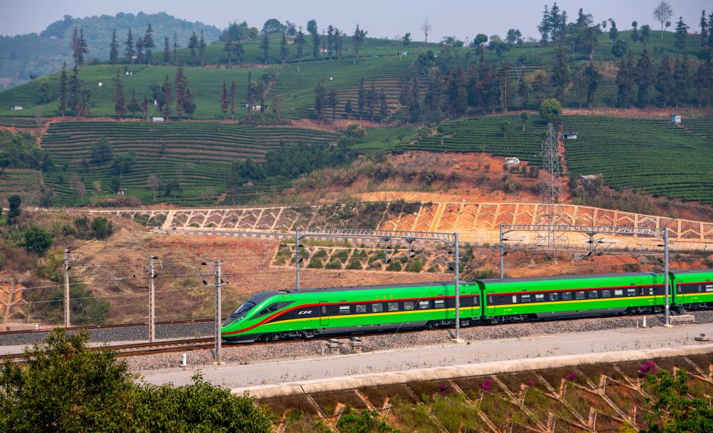 4月13日，首发列车驶过位于云南省普洱市的一处茶山。　新华社记者 江文耀 摄