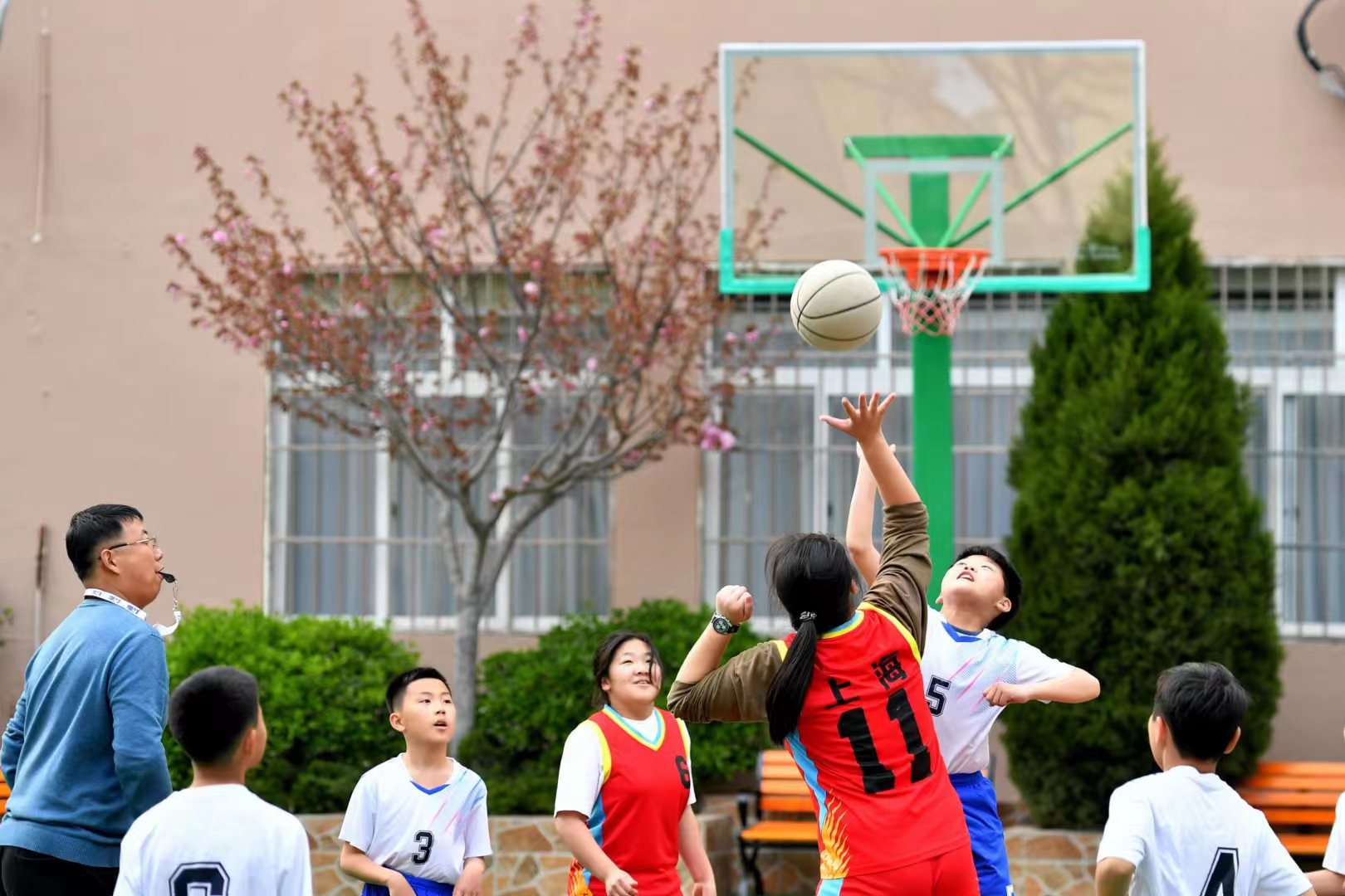 4月14日,在青岛市市北区上海路小学篮球场内,学生们在争夺发球.