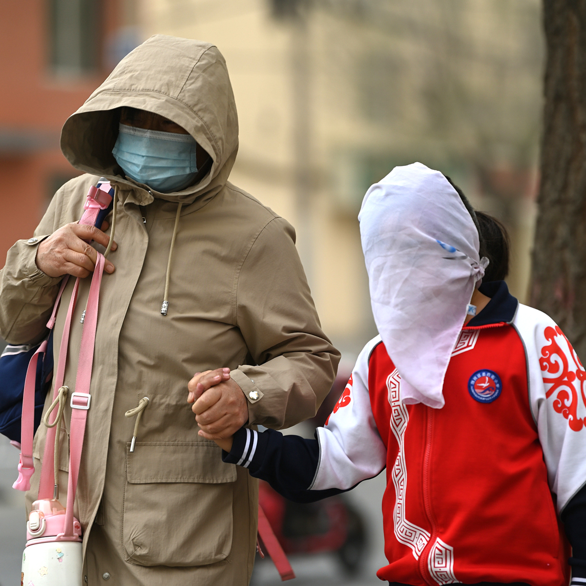 4月19日,呼和浩特出现风沙天气,行人头裹丝巾出行.